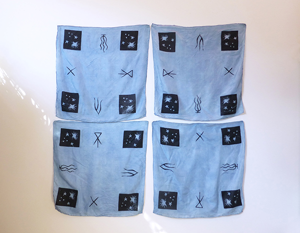 four indigo-dyed black-printed silk squares